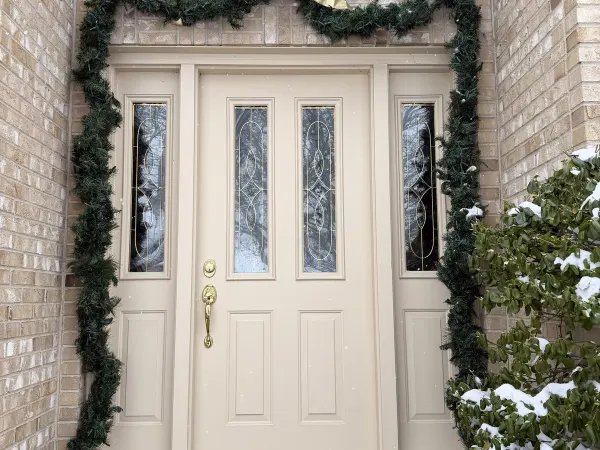 White arched entry door with seasonal wreath