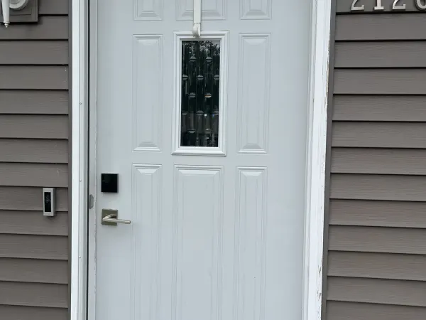 White entry door with blue trim and storm door