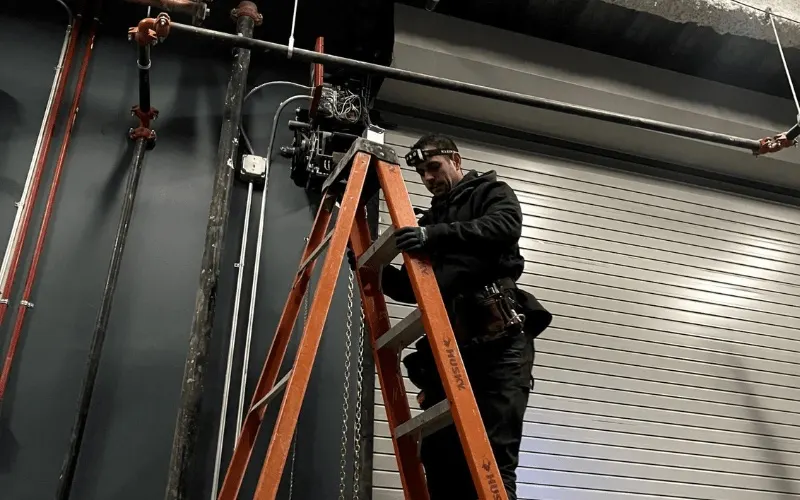 Overhead garage door cable assembly running along the side track to the bottom bracket