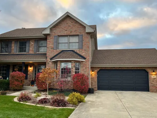Black garage door installed on a large brick home