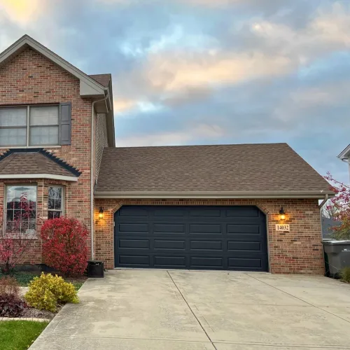 Black garage door installed on a large brick home in the Chicago Suburbs