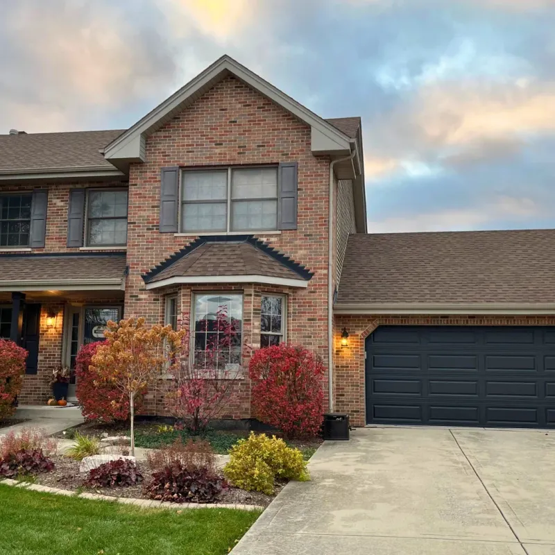 Black garage door installed on a large brick home in the Chicago Suburbs