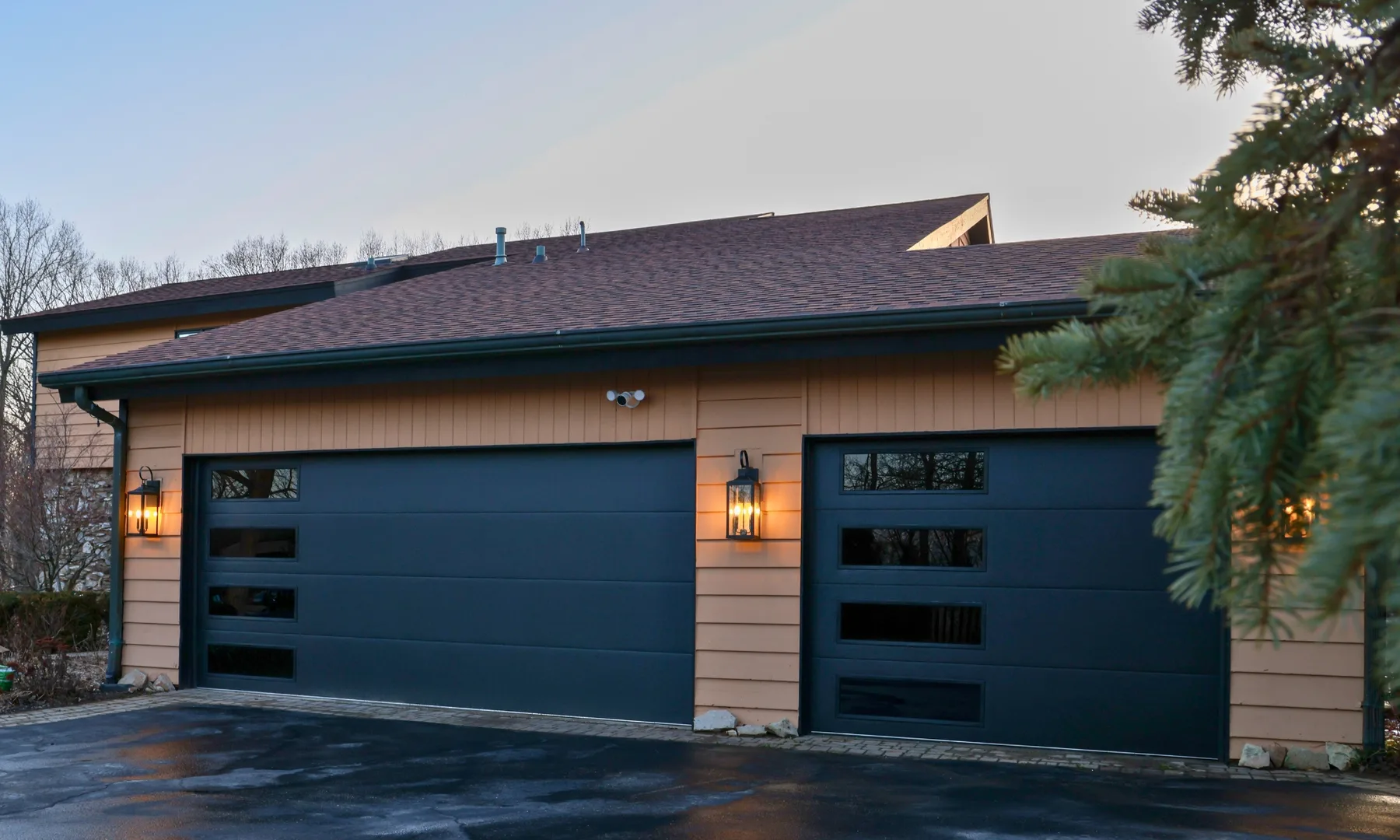 Two modern black garage doors with offset horizontal glass panels
