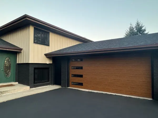 Modern wood-tone garage door installed on a home