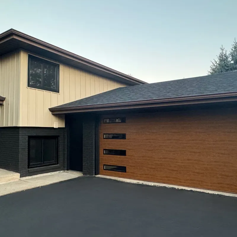 Modern wood-tone garage door installed on a residential home
