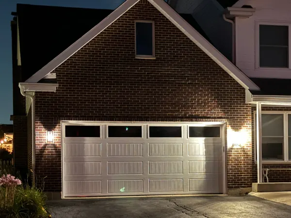 White garage door installation photographed at night