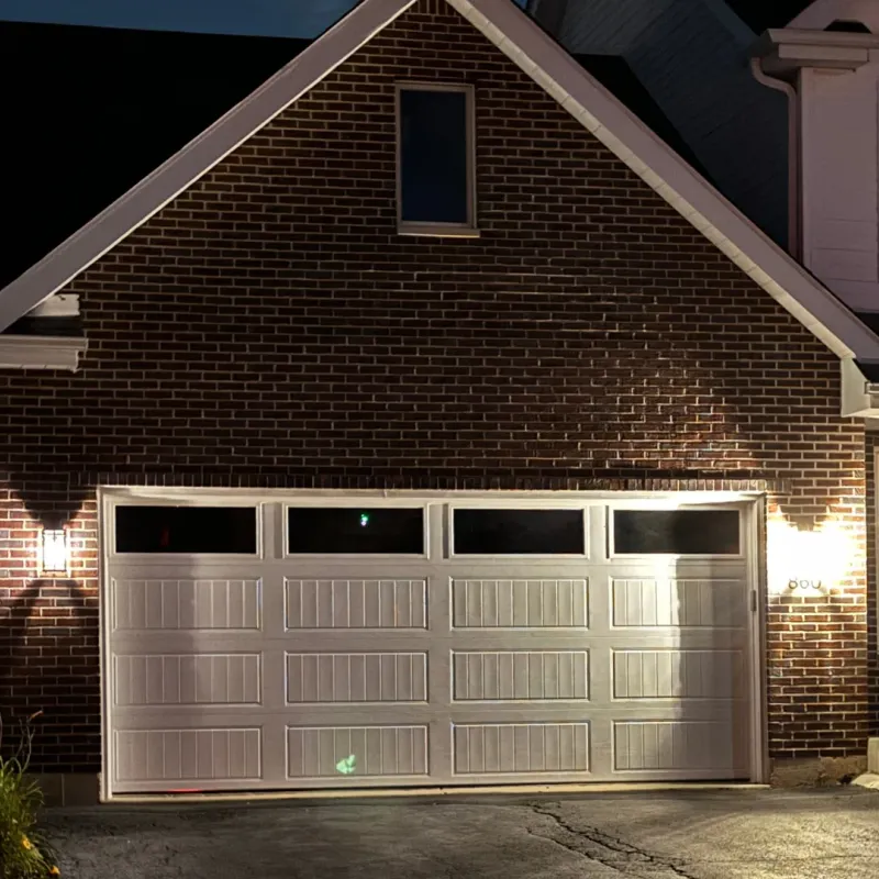 White garage door installation photographed at night