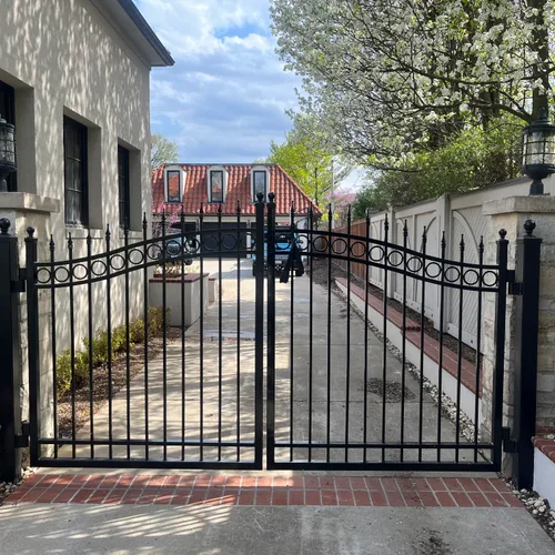 Black ornamental swing gates with stone pillars on a Chicagoland estate — installed by World of Doors