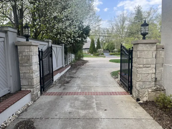 Iron residential driveway gate on a paver approach