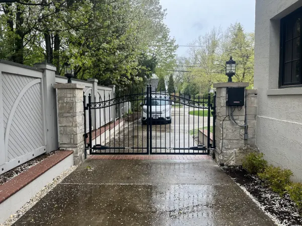 Iron driveway gate at a white residential home