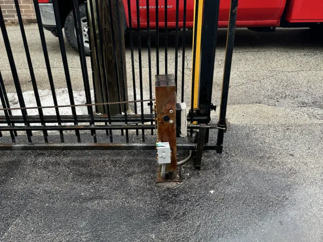 Hydraulic swing-gate operator mounted to the masonry pillar, run conduit to the control box, and tied into the gate leaf via the operator arm.