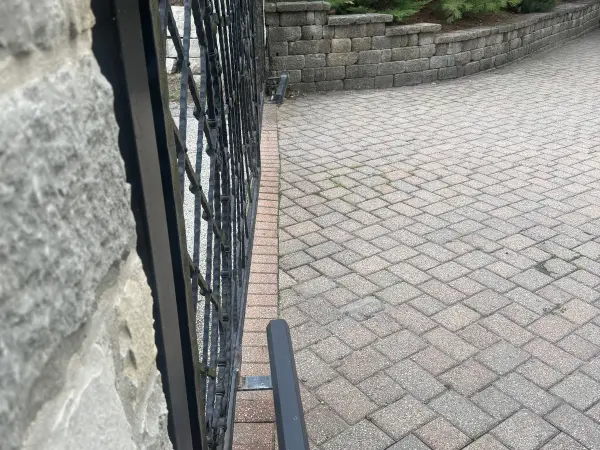 Commercial paver driveway with a black ornamental gate