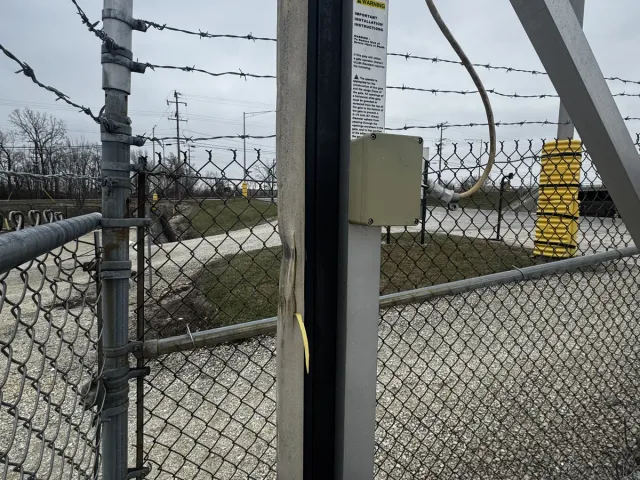 Cantilever slide gate on a commercial perimeter, operating through Chicagoland snow. Cold-weather operator and heated track for year-round reliability.