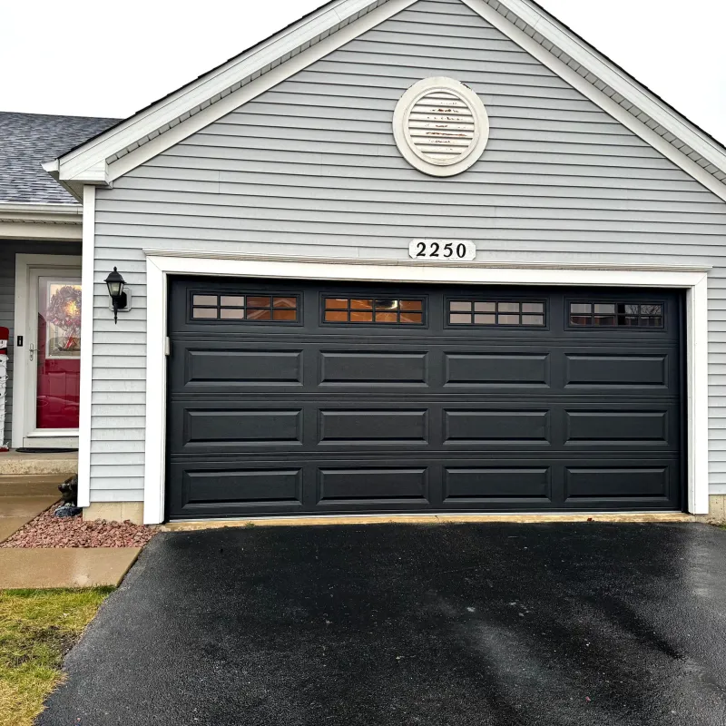 Carriage-style garage door with windows on a brick home