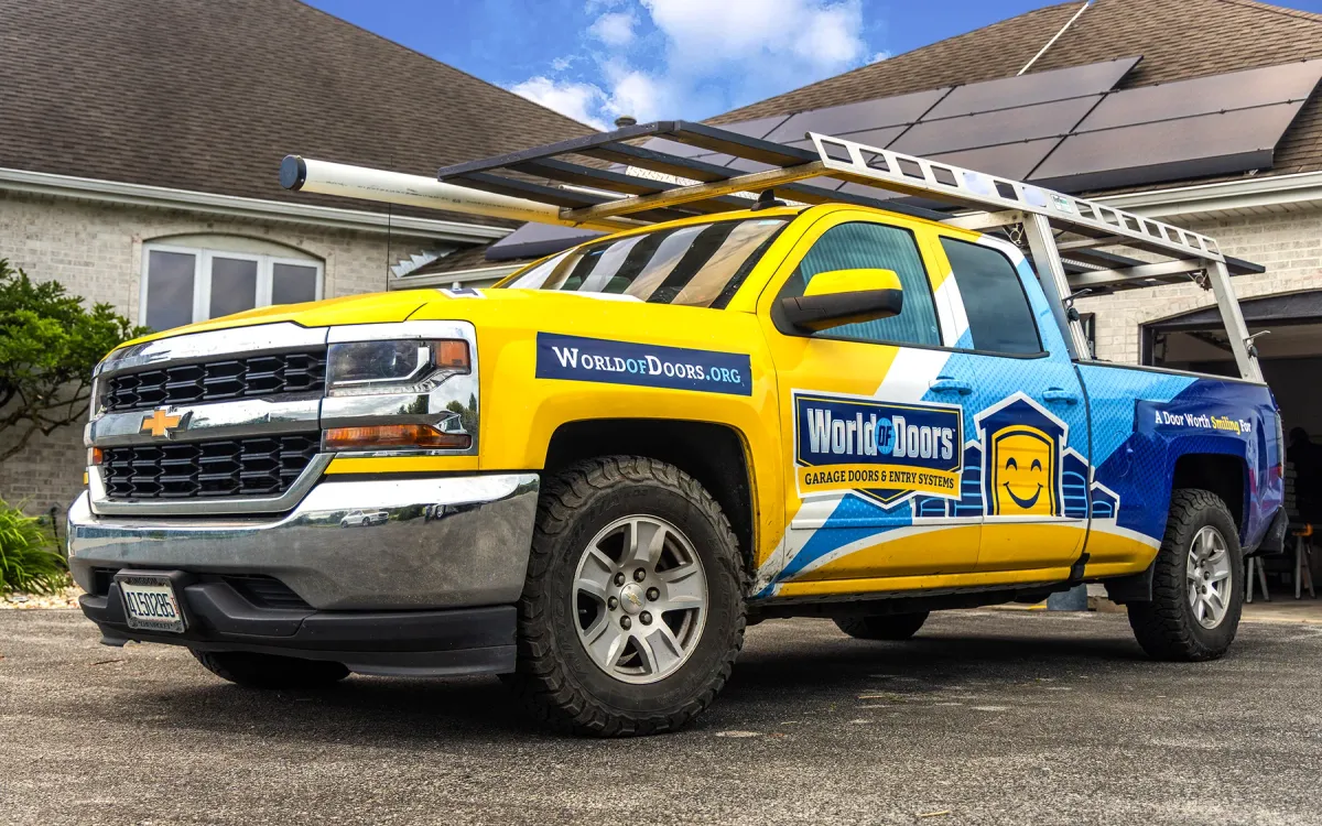 World of Doors branded service truck parked at a residential garage door service call