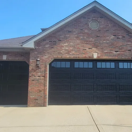 Two black sectional garage doors on a Chicago-area brick home