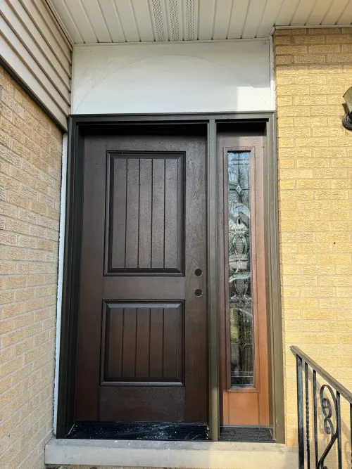 Dark brown entry door with a tall decorative glass sidelight