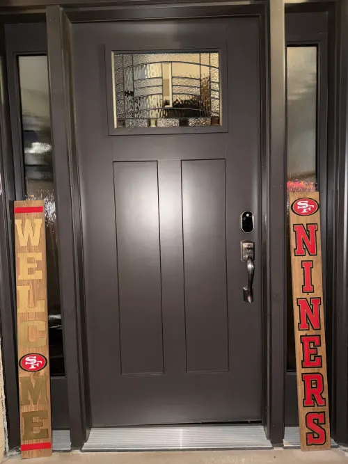 Dark gray Shaker-style entry door with sidelights and custom welcome boards