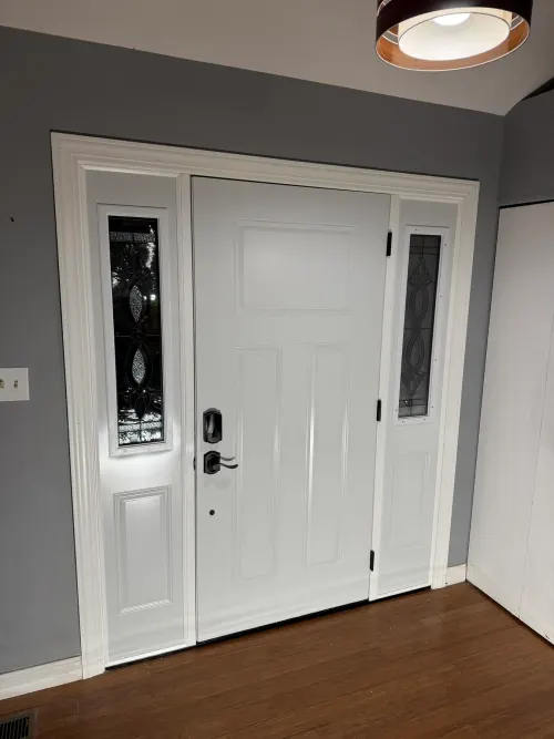 Interior view of a white entry door with decorative leaded-glass sidelights