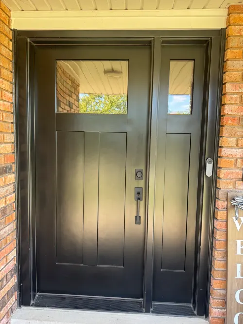 Black Shaker-style craftsman entry door with sidelights