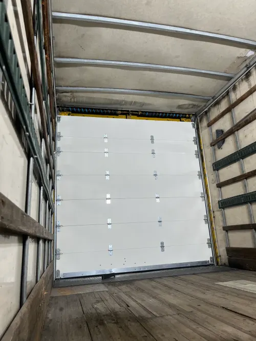 Close-up of new roll-up door panels and hardware inside a box truck