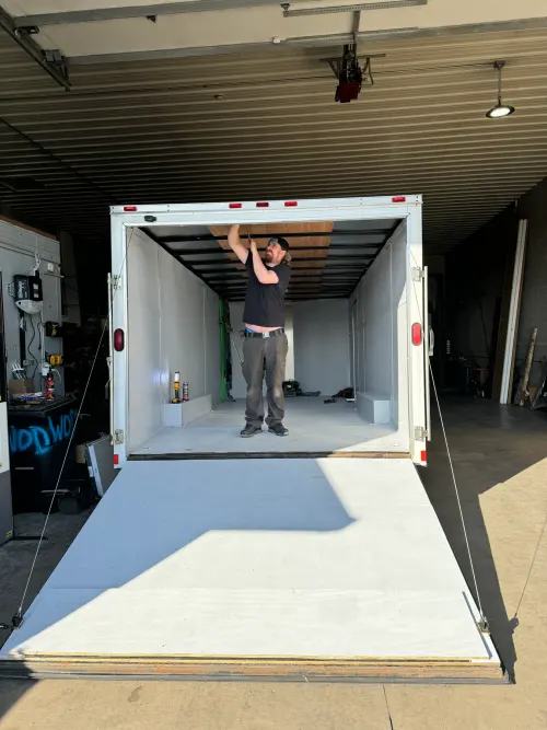 World of Doors technician working overhead inside a box truck cargo area