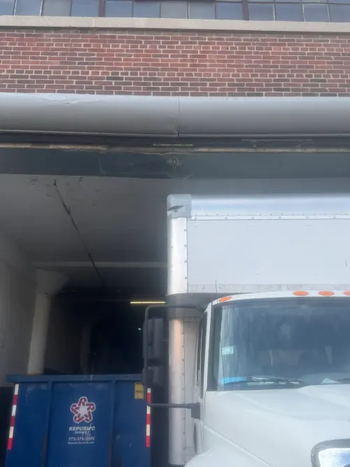 Box truck at a customer loading dock in an urban brick building