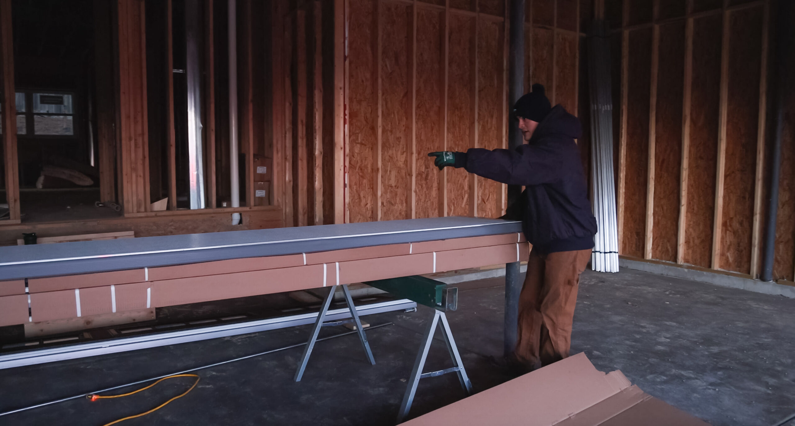 A man working on a piece of wood in an unfinished room