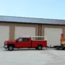 Red service truck from a trusted garage door supplier in Frankfort, prepared for commercial garage door installation.