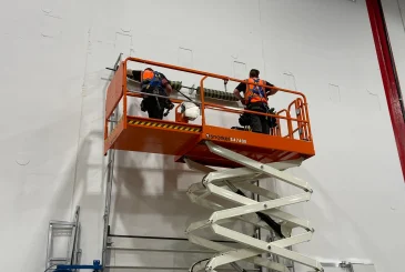 a-group-of-men-working-on-the-wall-of-garage-door