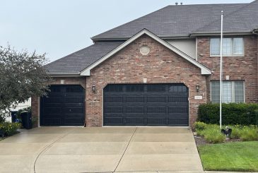 brick-house-with-two-black-garage-doors
