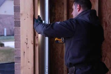 the man is grinding the metal of the garage door