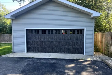 garage door-with-a-fence-and-a-trees-on-the-back