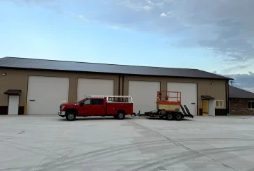 truck-pulling-a-trailer-in-front-of-a-big-garage-door