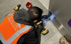 A man adding a kick plate to a commercial overhead door, also suitable for enhancing garage door durability and functionality.