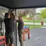 Technicians adjusting the garage door opener during a repair session.