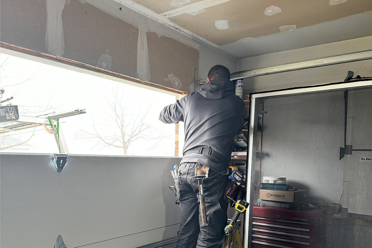 the technician fixing a piece of a garage door